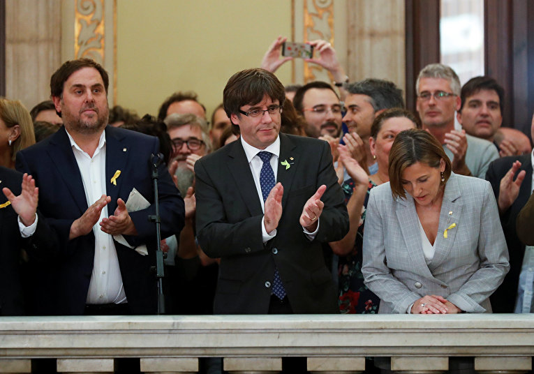 Глава Каталонии Карлес Пучдемон аплодирует после того, как региональный парламент Каталонии объявил независимость от Испании в Барселоне