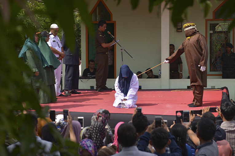 В Индонезии женщину публично наказывают за прелюбодеяния.