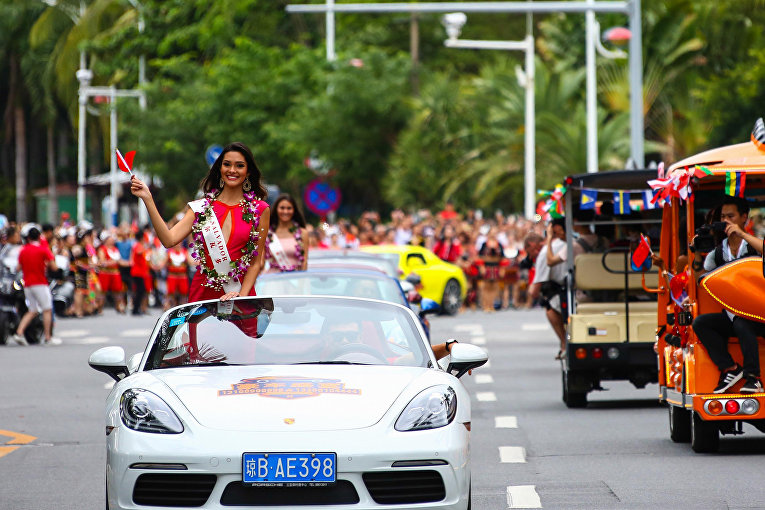 Участница конкурса Мисс Мира в Сальвадоре размахивает китайским национальным флагом на параде в честь открытия конкурса.