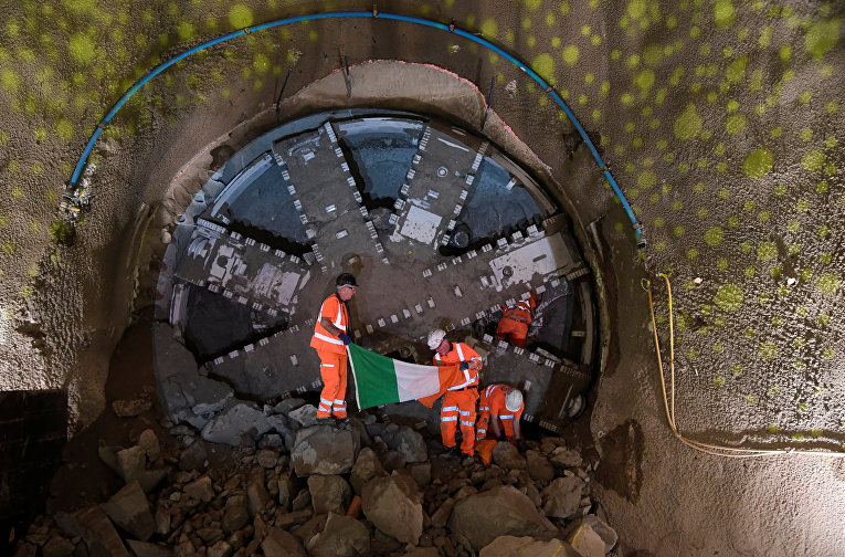Рабочие держат национальный флаг Ирландии в будущем тоннеле метро в районе Кеннингтон и Баттерси в Лондоне