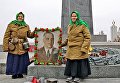Пожилые женщины с портретом маршала Жукова у памятника Вечный огонь в киевском Парке Славы
