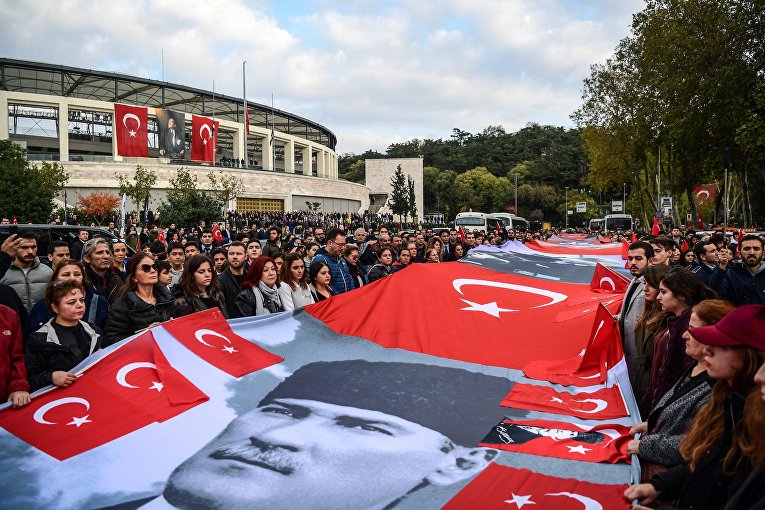 В Стамбуле люди держат флаги Турции портрет Мустафы Кемаль Ататюрка в годовщину его смерти