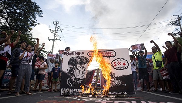 Протестующие сжигают антиамериканский баннер с лицом Дональда Трампа в канун начала саммита АСЕАН в Маниле