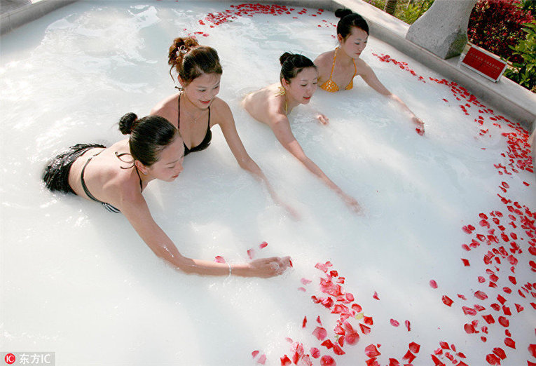 Женщины плавают в горячем источнике с добавлением молока и лепестков роз
