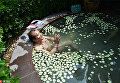 Мужчина наслаждается ванной с дольками огурца в  горячем источнике в Лояне
