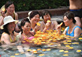 Туристы наслаждаются горячими источниками с апельсинами на курорте в Лояне