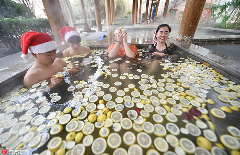 Люди отдыхают в горячем источнике с кусочками лимона в Лояне