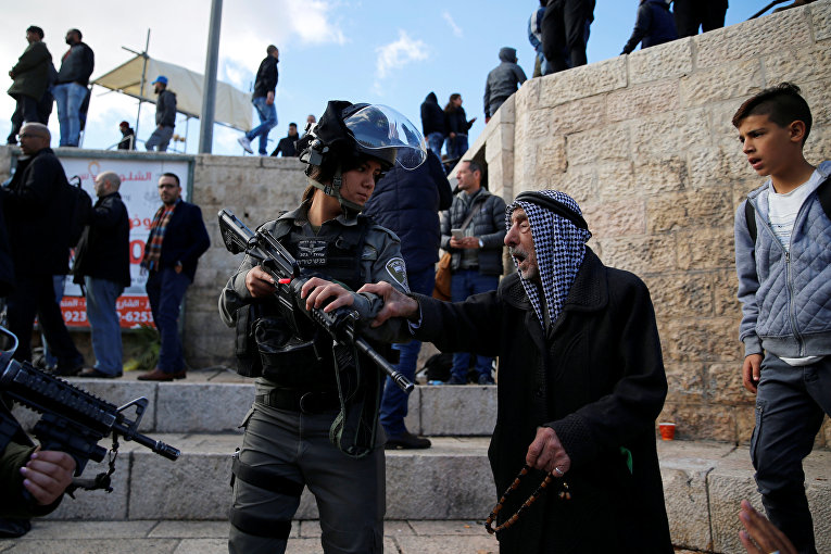 Палестинский мужчина спорит с израильской пограничной полицейской во время протеста после заявления президента США Дональда Трампа о том, что он признал Иерусалим столицей Израиля, недалеко от ворот Дамаска в Старом городе Иерусалима