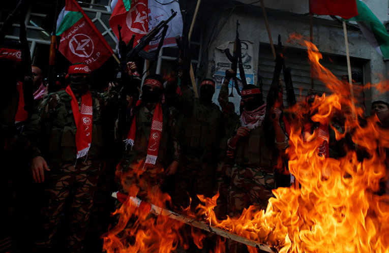 Палестинские боевики PFLP сжигают изображения израильского флага и флага США во время протеста против решения Трампа признать Иерусалим столицей Израиля в городе Газа