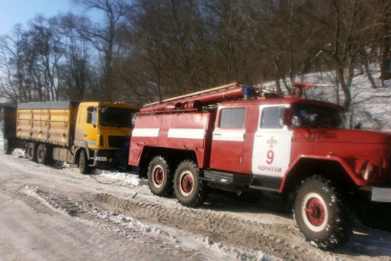 Спасатели вытаскивают из снежных заносов грузовики