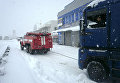 Спасатели вытаскивают из снежных заносов грузовики