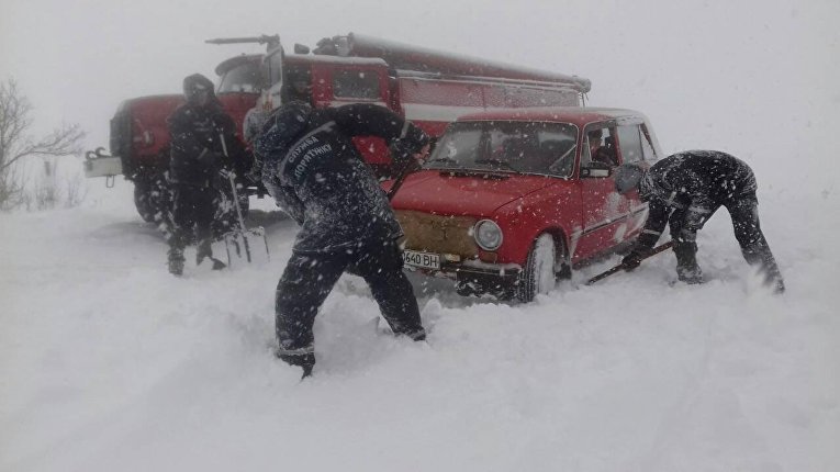 Спасатели вытаскивают из снежных заносов автомобили