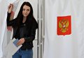 Девушка голосует на выборах президента РФ на избирательном участке в Бахчисарае