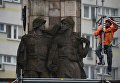 Рабочий монтирует строительные леса у памятника благодарности Красной армии в центре города Щецин