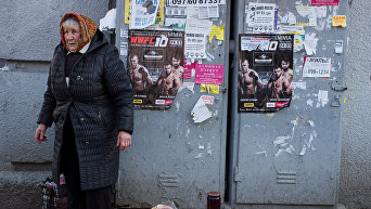 Пожилая женщина торгует на улице