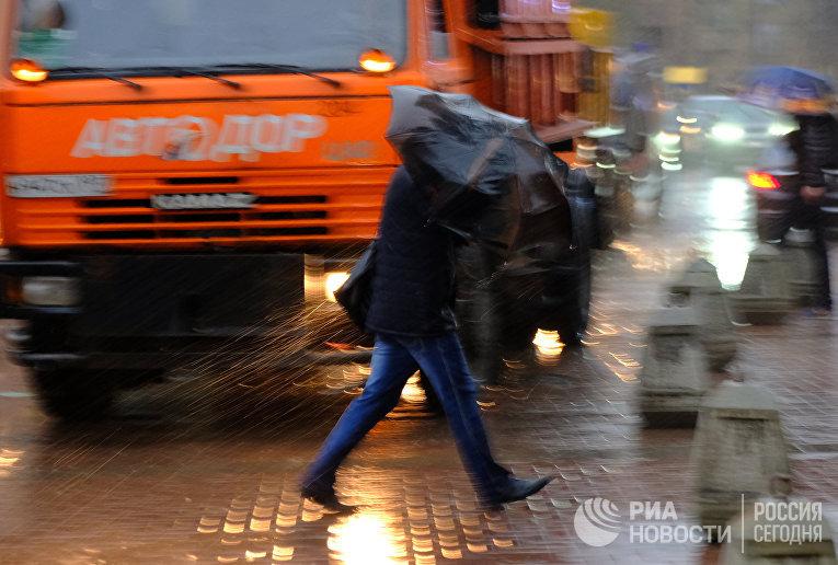 Пешеходы на улице в Москве во время сильного дождя