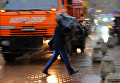 Пешеходы на улице в Москве во время сильного дождя
