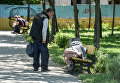 Бездомная женщина спит на скамейке на Подоле в Киеве