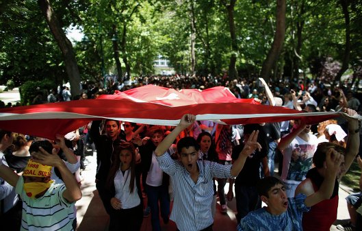 Протестующие несут турецкий флаг