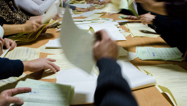 Сотрудники участковой избирательной комиссии ведут подсчет бюллетеней на избирательном участке Харькова после окончания выборов в Верховную Раду Украины.