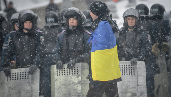 Мужчина с национальным флагом Украины перед оцеплением на улице Грушевского у здания администрации президента Украины в Киеве