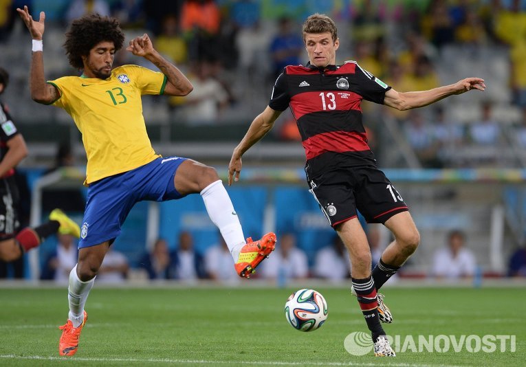 Игрок сборной Бразилии Данте Бонфим и игрок сборной Германии Томас Мюллер (справа)