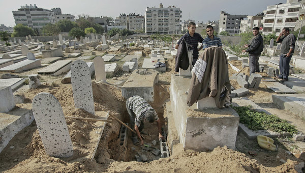 Мужчина делает новую могилу на кладбище в Газе.
