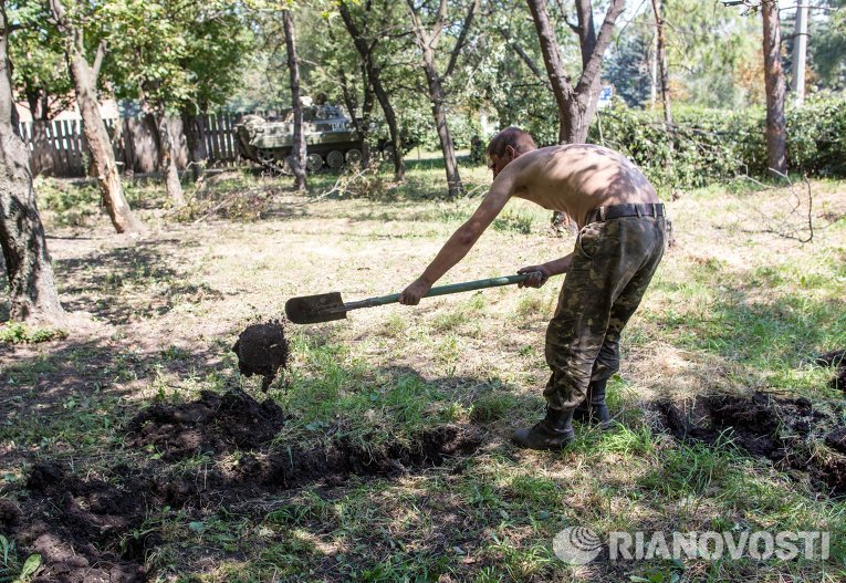 Пленный украинский военный роет могилу для погибших сослуживцев