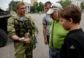Ополченец показывает людям гранату во во время патрулирования площади Ленина в Донецке