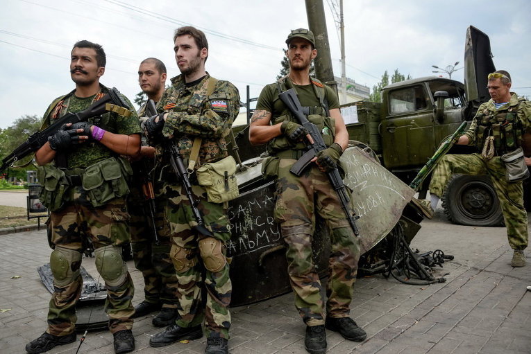 Французские добровольцы, сторонники ополчения, возле разрушенных украинских военных машин в Донецке