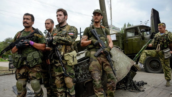 Французские добровольцы, сторонники ополчения, возле разрушенных украинских военных машин в Донецке