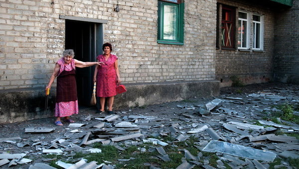 Местные жители стоят возле здания, где они живут, после обстрела в Донецке