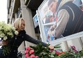 Коллега возлагает цветы в память о погибшем фотокорре Андрее Стенине