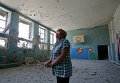 Преподаватель гимназии  осматривает повреждения в помещении  школы в селе Спартак