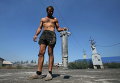 Мужчина демонстрирует остатки разорванного снаряда в селе Спартак