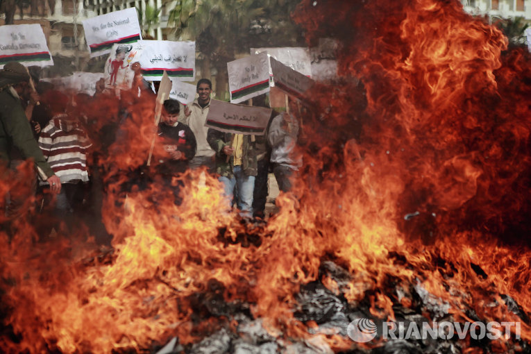 Жители Бенгази сжигают портреты Муаммара Каддафи, плакаты с его цитатами и Зеленую книгу Каддафи