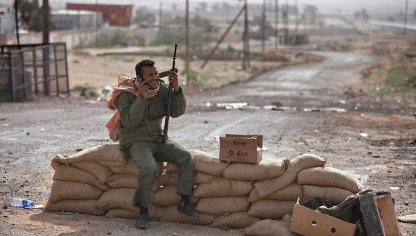 Боец с автоматом на блокпосту у дороги на въезде в восточноливийский город Марса-эль-Брега, контролируемый повстанцами