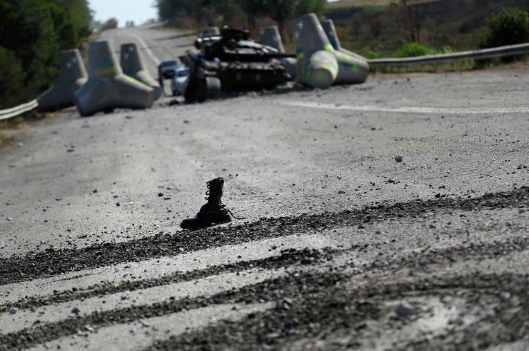 Солдатский ботинок у разбитого танка украинских военных близ села Лебединское