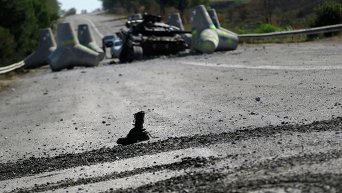 Солдатский ботинок у разбитого танка украинских военных близ села Лебединское