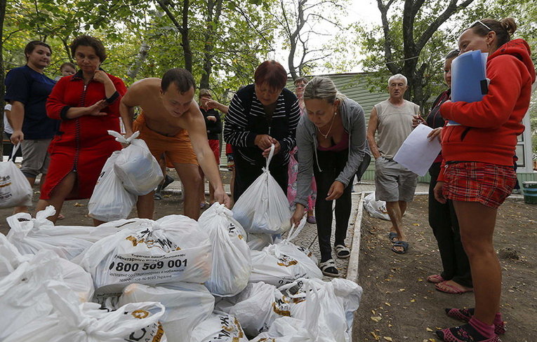Украинские беженцы из Донецкой области получают продукты в качестве гуманитарной помощи в Мариуполе
