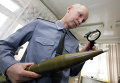 Специалист лаборатории взрывотехнических экспертиз исследует боеприпас