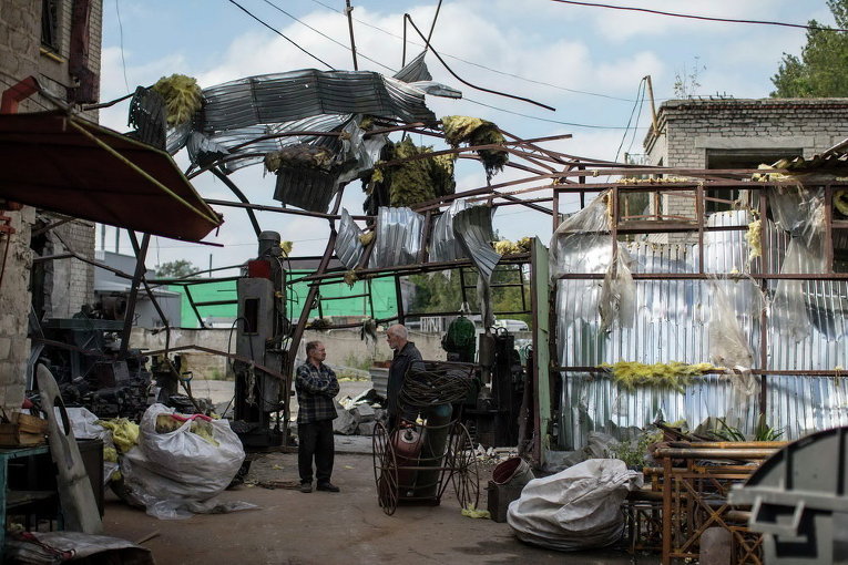 Местные жители на разрушенной фабрике в Донецке