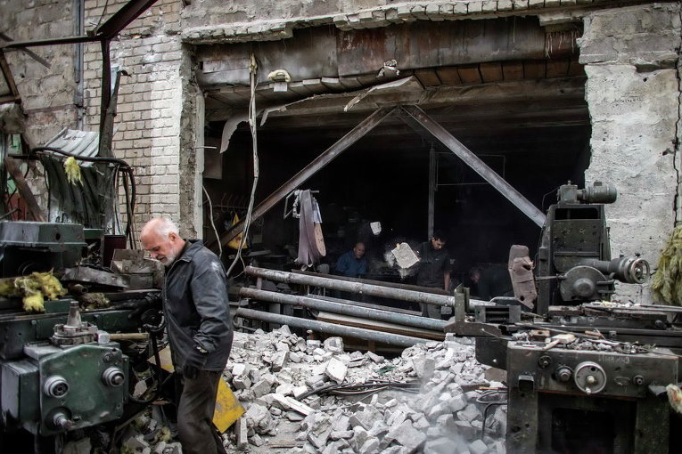 Люди на разрушенной фабрике в Донецке