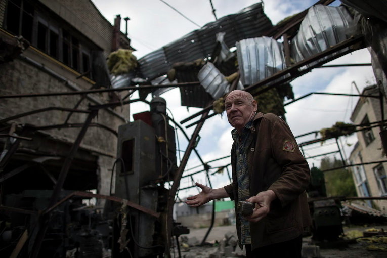 Мужчина на разрушенном заводе в Донецке