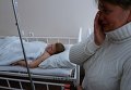 Оксана Сафонова возле своего сына Кирилла, пострадавшего при обстреле спортплощадки в Донецке