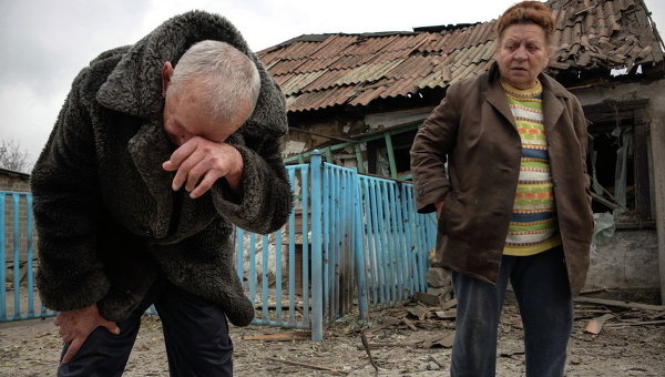 Местные жители у своего разрушенного дома в Донецке