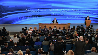 Владимир Путин (в центре на дальнем плане) на десятой большой ежегодной пресс-конференции