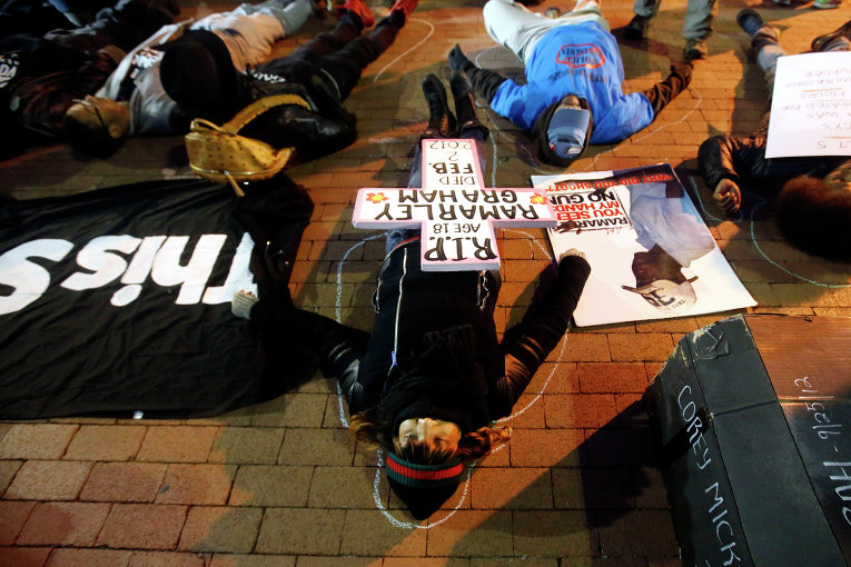 Констанс Малькольм, мать убитого полицейского и другие протестующие лежат на земле