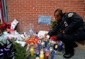 Офицер полиции Нью-Йорка Мари Жан-Батист зажигает свечу у мемориала в память о погибших полицейских