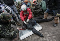 Сторонники оппозиции оказывают помощь раненому во время столкновений.